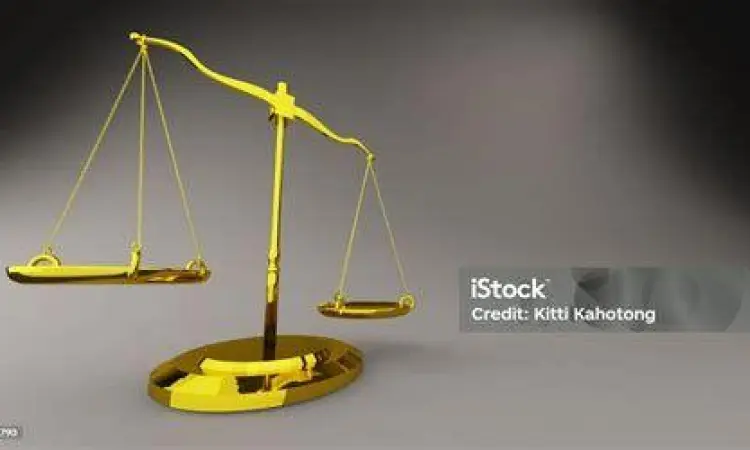 Simbol timbangan keadilan emas di atas meja kayu