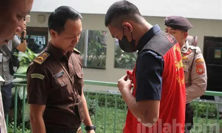Terdakwa mengenakan pakaian kemeja putih rapi dalam persidangan